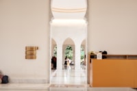 a hallway in a building with white walls and arches